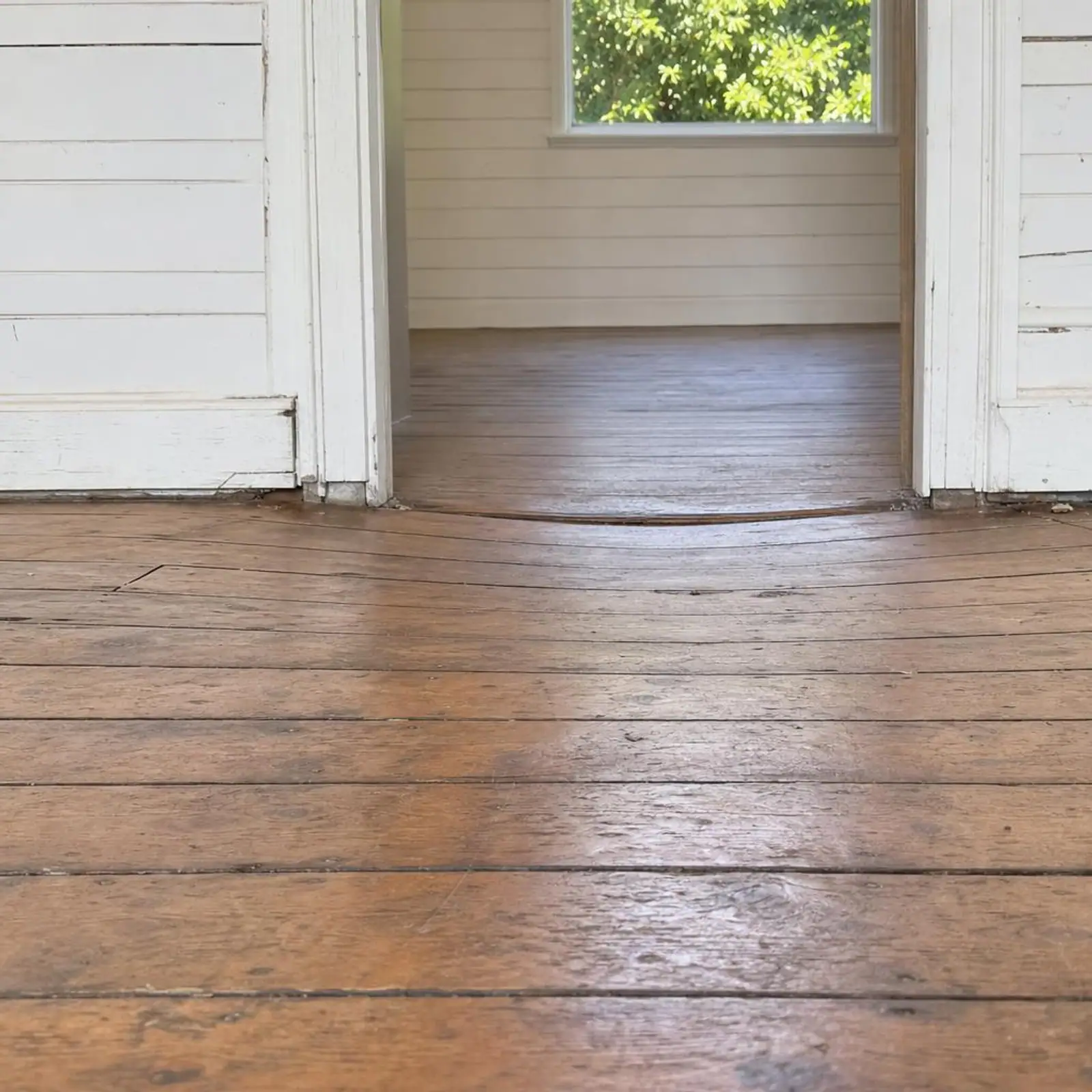 Close-up of a timber floor with a visible dip across the boards
